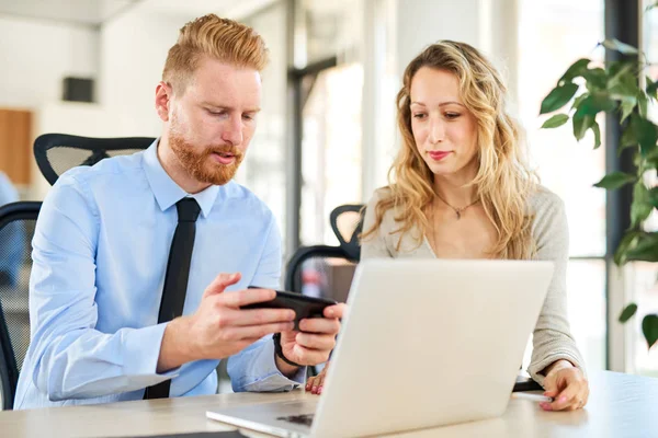 Ofiste çalışan iki arkadaşları, o bir şey ona onun Smartphone'da gösteriyor