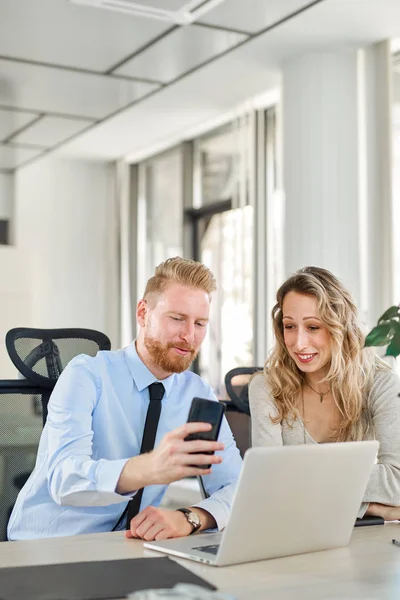 Ofiste çalışan iki arkadaşları, o bir şey ona onun Smartphone'da gösteriyor