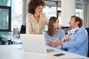 Üç meslektaşları ofiste sohbet. Danışma laptop. İş kavramı başlatmak.