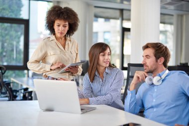 Üç meslektaşları ofiste sohbet. Danışma laptop. İş kavramı başlatmak.