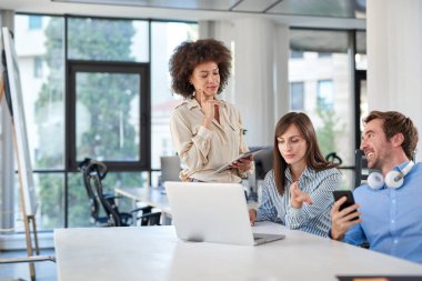 Üç meslektaşları ofiste sohbet. Danışma laptop. İş kavramı başlatmak.