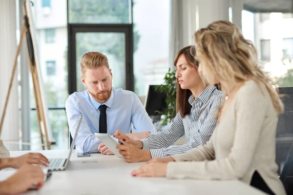 Küçük grup masada oturan ve toplantı olan iş adamları. Çok kültürel grubunu.