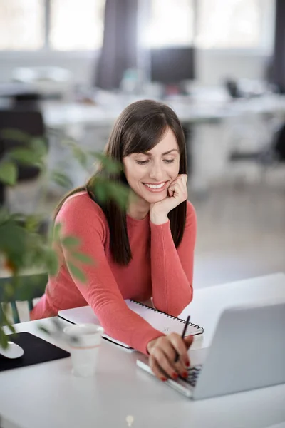 Schöne lächelnde kaukasische Geschäftsfrau sitzt im modernen Büro und benutzt Laptop. — Stockfoto