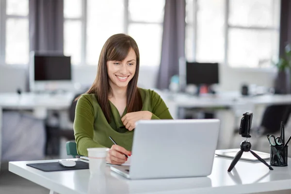 Schöne lächelnde kaukasische Geschäftsfrau sitzt im modernen Büro und benutzt Laptop. — Stockfoto