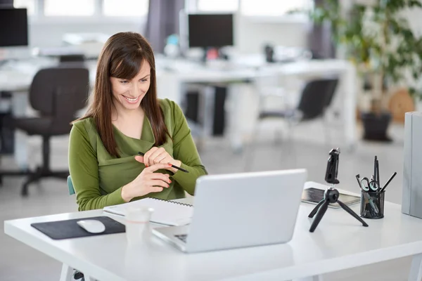 Bella donna d'affari caucasica sorridente seduta in ufficio moderno e utilizzando il computer portatile . — Foto Stock