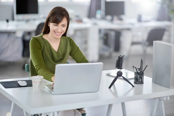 Bella donna d'affari caucasica sorridente seduta in ufficio moderno e utilizzando il computer portatile . — Foto Stock