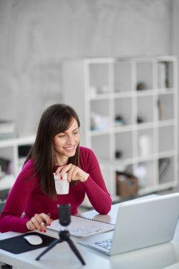 Modern ofiste otururken rahat gitmek laptop ve driking kahve büyüleyici Kafkas meşgul esmer giyinmiş.