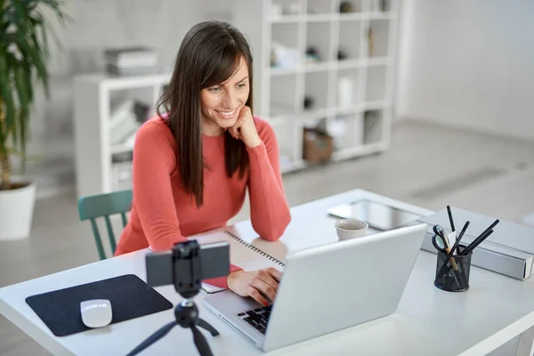 Schöne lächelnde kaukasische Geschäftsfrau sitzt im modernen Büro und benutzt Laptop. — Stockfoto