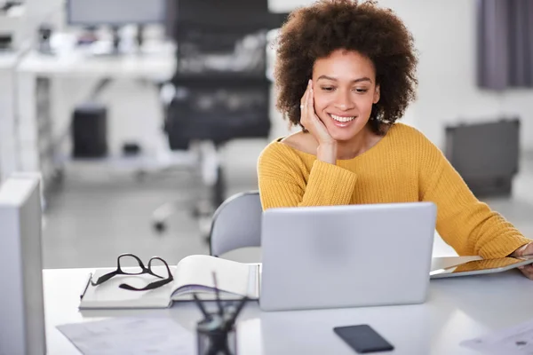 Schöne lächelnde gemischte Rasse Geschäftsfrau lässig gekleidet im Büro sitzend und mit Laptop. — Stockfoto