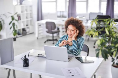 Modern ofiste otururken nasıl bir sorunu çözmek için rahat düşünme giyinmiş Sevimli karışık ırk iş kadını.