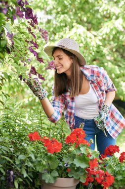 Muhteşem Kafkas esmer çalışma giysileri ve şapka baş arka bahçesinde wlowers kokulu.