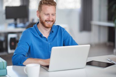 Genç Kafkas çalışanı ofiste oturuyor ve dizüstü bilgisayarda yazıyor. İş konseptini başlatın.