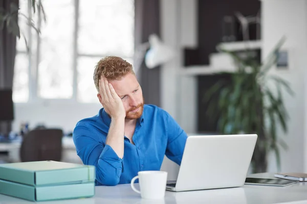 Nervous Caucasian male employee having headache while sitting in office. Bad day at work concept. — Stock Photo, Image