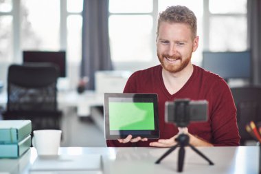 Yakışıklı Kafkas çalışanı internet üzerinden sunum yapıyor. Ellerde tablet. İş konseptini başlatın.