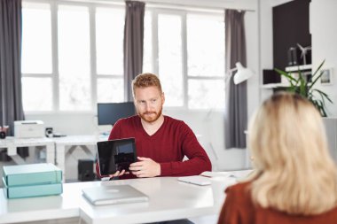 Yakışıklı Kafkas yöneticisi, çalışan iş stratejisine tablette gösteriyor. İş konseptini başlatın.