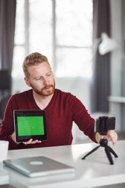 Yakışıklı Kafkas çalışanı internet üzerinden sunum yapıyor. Ellerde tablet. İş konseptini başlatın.