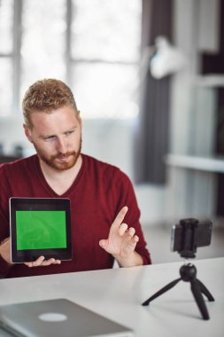 Yakışıklı Kafkas çalışanı internet üzerinden sunum yapıyor. Ellerde tablet. İş konseptini başlatın.