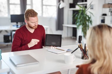 Yakışıklı Kafkas yöneticisi, çalışan iş stratejisine tablette gösteriyor. İş konseptini başlatın.