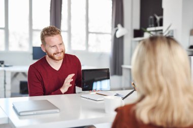 Yakışıklı Kafkas yöneticisi, çalışan iş stratejisine tablette gösteriyor. İş konseptini başlatın.
