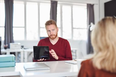 Yakışıklı Kafkas yöneticisi, çalışan iş stratejisine tablette gösteriyor. İş konseptini başlatın.