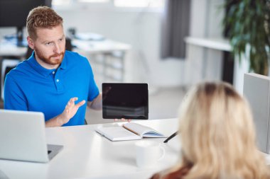 Yakışıklı Kafkas yöneticisi, çalışan iş stratejisine tablette gösteriyor. İş konseptini başlatın.