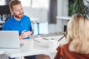 Yakışıklı Kafkas yöneticisi, çalışan iş stratejisine tablette gösteriyor. İş konseptini başlatın.