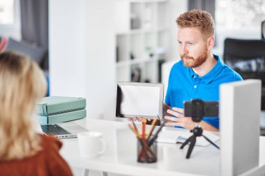 Yakışıklı Kafkas odaklı çalışan tablet tutan ve hisse senedi satın almak için kadın müşteri ikna etmeye çalışıyor.