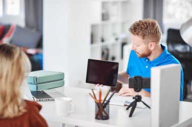 Yakışıklı Kafkas odaklı çalışan tablet tutan ve hisse senedi satın almak için kadın müşteri ikna etmeye çalışıyor.