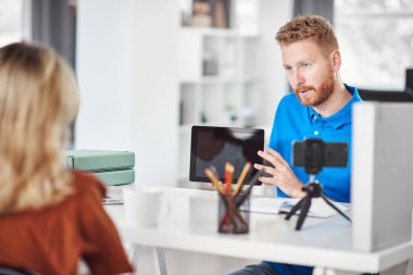 Yakışıklı Kafkas odaklı çalışan tablet tutan ve hisse senedi satın almak için kadın müşteri ikna etmeye çalışıyor.