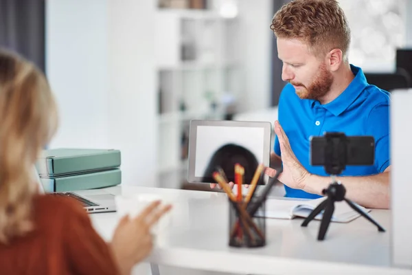 Guapo caucásico centrado empleado celebración tableta y tratando de convencer a cliente femenino para comprar acciones . — Foto de Stock