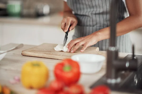 Primer plano de la mujer de raza mixta en el delantal de pie en la cocina y cortar setas . — Foto de Stock