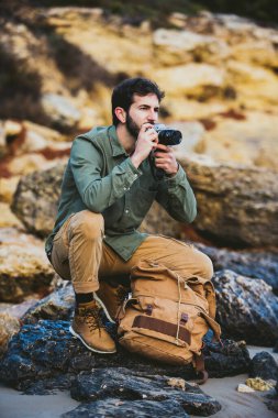Dışarıda fotoğraf çeken genç adamın portresi.