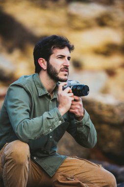 Dışarıda fotoğraf çeken genç adamın portresi.