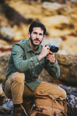 Dışarıda fotoğraf çeken genç adamın portresi.