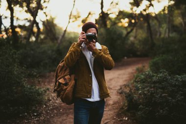 Dışarıda fotoğraf çeken genç adamın portresi.