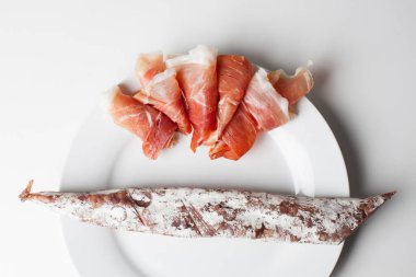 Beyaz tabakta İspanyol jambonu ve sosis.