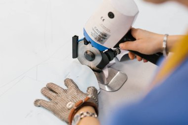 Tekstil desenini testereyle kesen kadın.