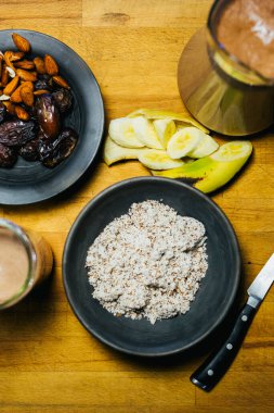 Tahta bir masada ezilmiş badem, muz ve hurma meyvesi. Doğal ve sağlıklı bir meyve suyuna hazır.