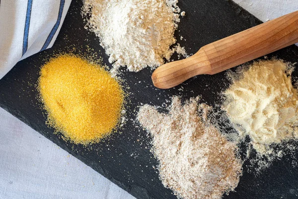 Angri, İtalya. Beyaz un, kepekli un, kepekli lağım faresi, polenta unu gibi farklı türde un, tahta üzerine dizilmiş. Yakınlarda bir merdane var..