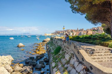Gaeta, İtalya. 12 Ağustos 2017. Genç bir çift Gaeta güvertesi boyunca alçak bir duvarda oturuyor..