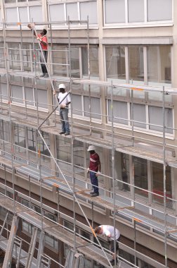 Mannheim, Almanya, 1 Eylül 2008. Üçü siyah, biri beyaz olmak üzere dört miğferli işçi, bir binanın yenilenmesi için bir inşaat şantiyesinde çalışıyor..