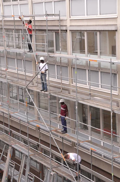 Mannheim, Almanya, 1 Eylül 2008. Üçü siyah, biri beyaz olmak üzere dört miğferli işçi, bir binanın yenilenmesi için bir inşaat şantiyesinde çalışıyor..