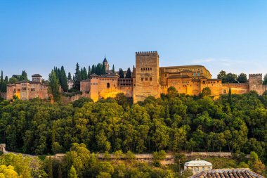 Granada, İspanya. 17 Ekim 2020. Suni ışıklarla aydınlatılan Alhambra kulelerinin ve binaların altından gün batımını izleyin..