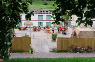 Mannheim, Almanya. 30 Nisan 2010. Neckar nehir kıyısındaki şehir plajında insanlar güverte sandalyelerinde gevşeyip sohbet ediyor ve içki içiyorlar..