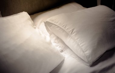 Uzun bir uyku uyanma sonra yatak odasında pis beyaz yastık.