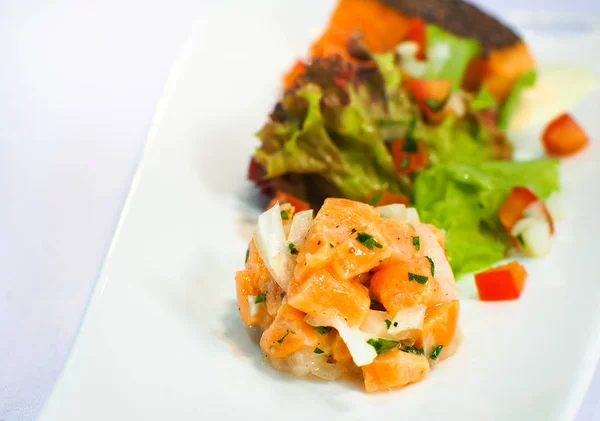 salmon sashimi served with salad on white plates. Fusion food image.