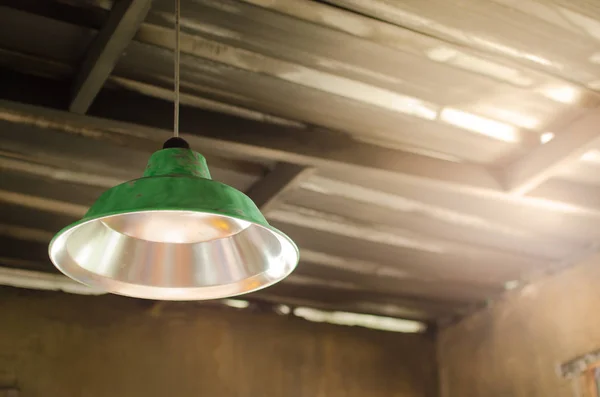 Green old lamps hang above on ceiling of an abandoned house in an old zinc. With space for place your text.