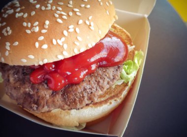 Kahverengi kağıt üzerinde et ile hamburger veya sandviç seçici odak. Domates soslu lezzetli domuz sandviç hamburger.