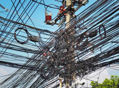 Elektrik direğindeki birçok elektrik kablosu, telefon hattı ve CCCTV Bangkok, Tayland 'daki her sokakta kablo ve kablo kaosu..