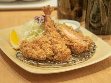 Karides tonkatsu bifteği, kızarmış domuz eti ve doğranmış lahana ve Japon yemeği ile servis edilmiş kızarmış ekmek..